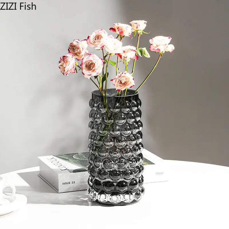 A sleek black glass hydroponics plant pot with textured bubble pattern holding pink and white roses for living room table