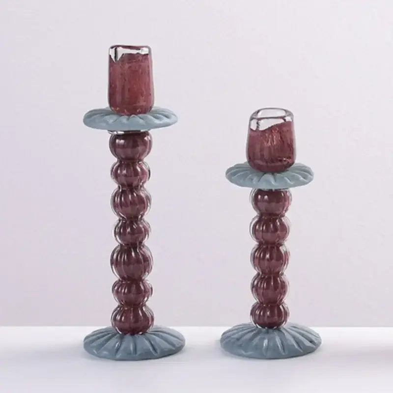 A pair of textured burgundy and light blue geometric glass candlestick holders with beaded column design for decorbites