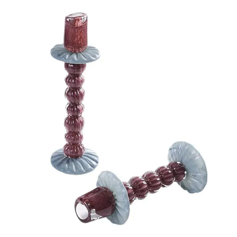 A pair of textured burgundy and light blue geometric glass candlestick holders with bead-like segments for dining room decorbites