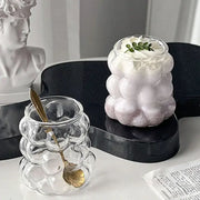 Clear glass drinking set with bubbly textured surface and gold spoon for elegant dining room use