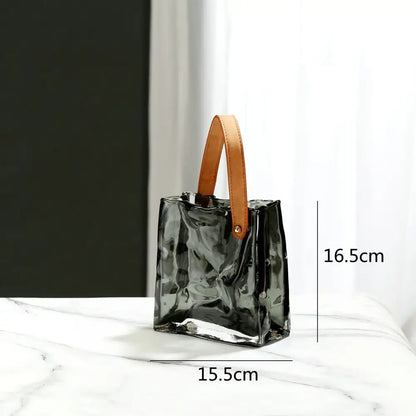 A sleek translucent black glass handbag with tan leather handle styled as decorbites clear glass living room decor