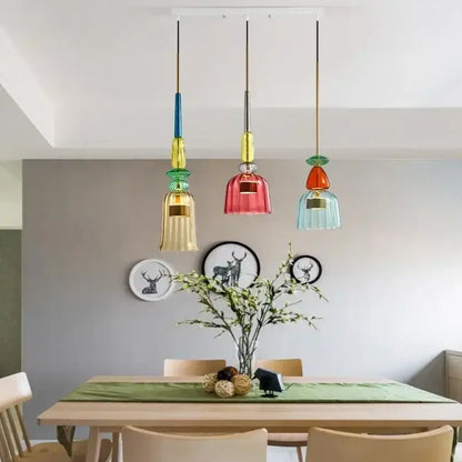 Three colorful textured glass pendant lights hang from the ceiling for kitchen and dining room chandelier use