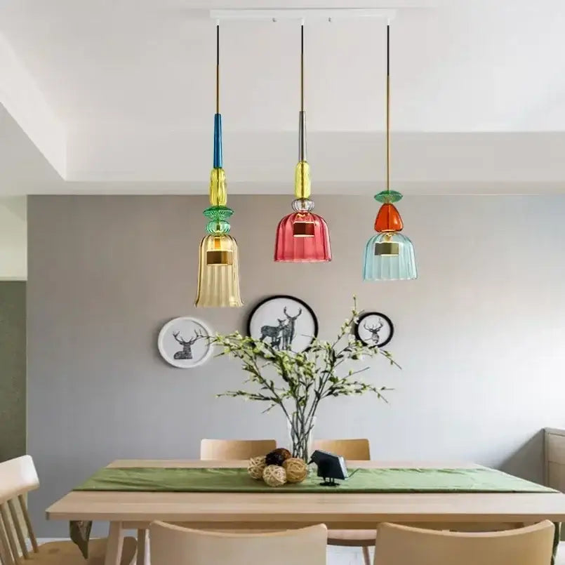 Three colorful textured glass pendant lights hang from the ceiling for kitchen and dining room chandelier use