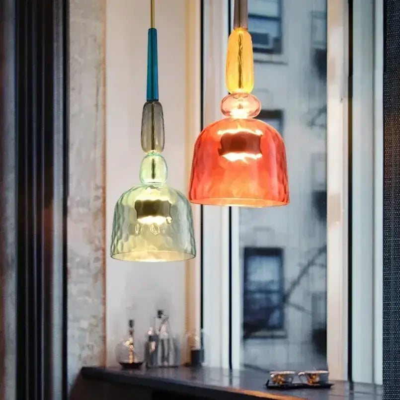 Two colorful glass pendant lights with textured green and orange bell-shaped shades for kitchen dining chandelier