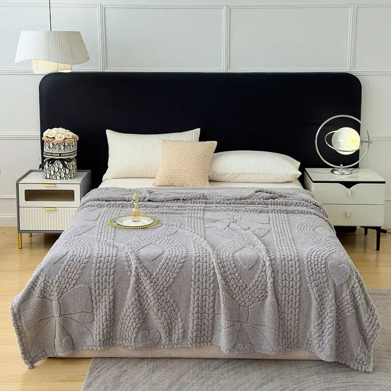 Gray textured throw blanket with raised knit patterns and plush finish used as a sofa cover blanket for living room