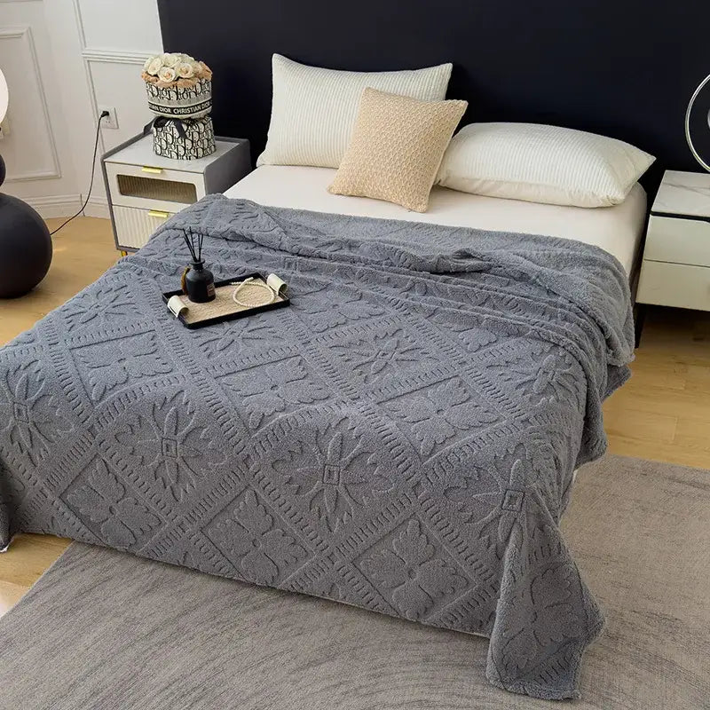 Gray textured throw blanket with raised floral and geometric patterns as a sofa cover blanket for living room use