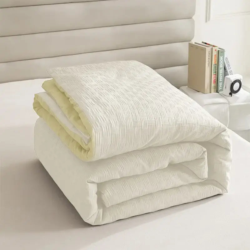 A neatly folded textured cream and pale yellow pillowcase quilt set with subtle pattern for bedroom bedding decorbites comforter