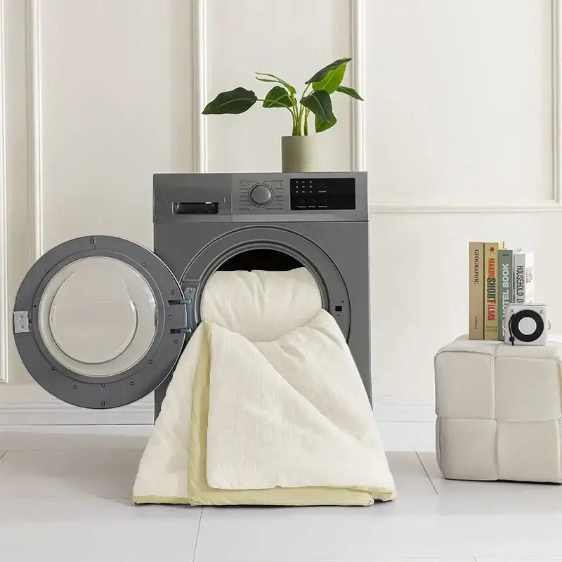Gray front-loading washing machine with open door contains cream-colored quilt from textured cream and pale yellow pillowcase quilt set decorbites comforter