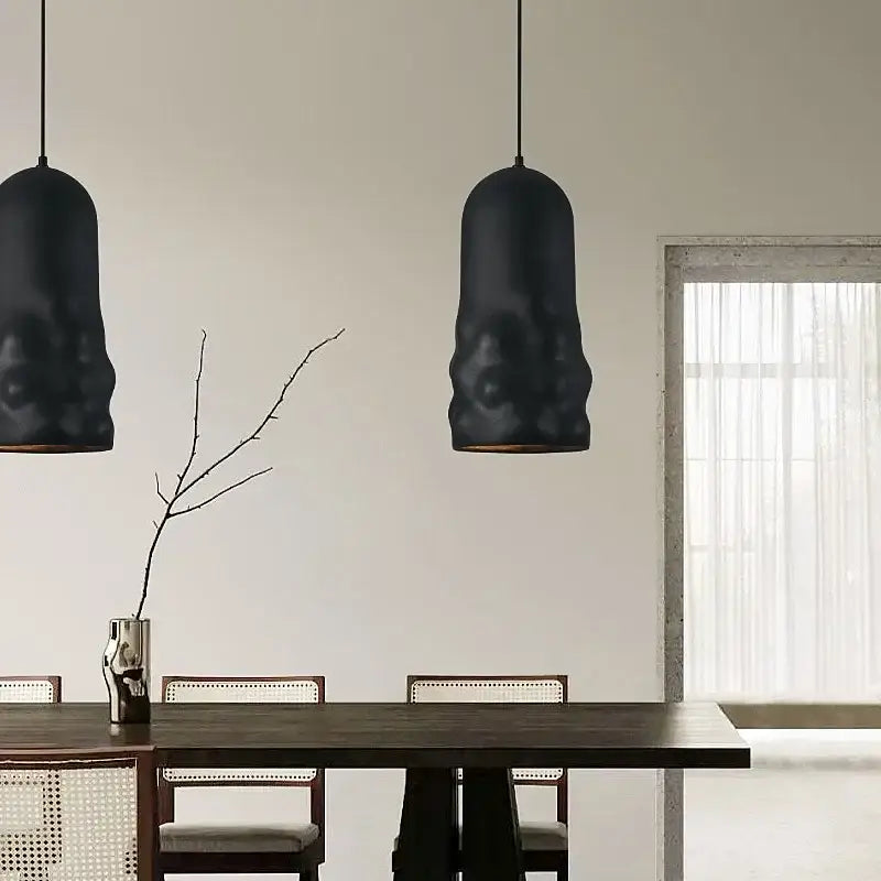 Two matte black textured creamy wind pendant lamps hang from the ceiling enhancing dining room decorbites pendant lamps