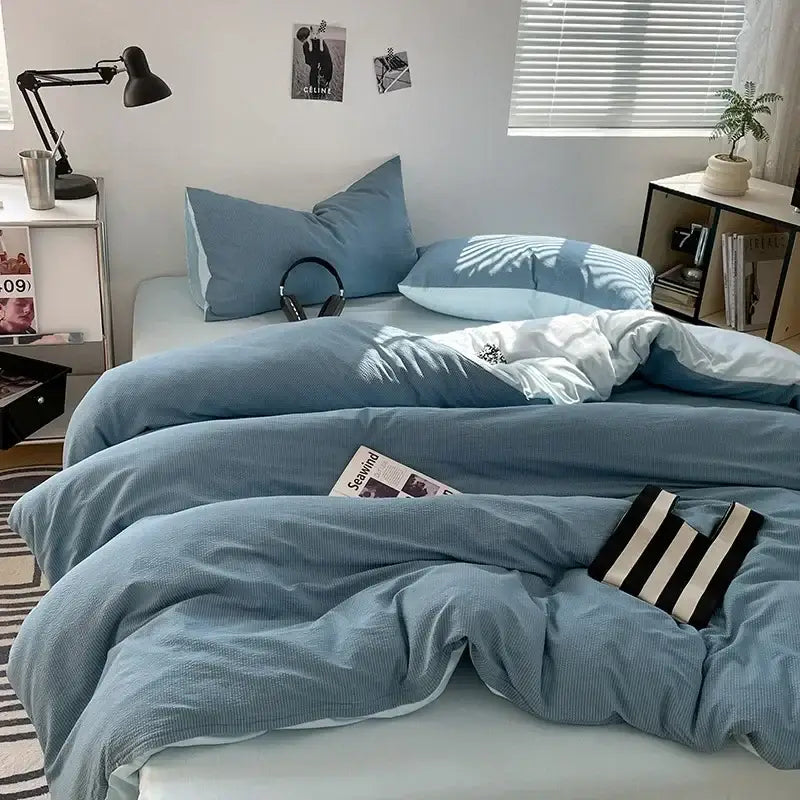 Blue corduroy duvet set with white lining and striped accessory on textured dark gray and light gray bubble cotton quilt set