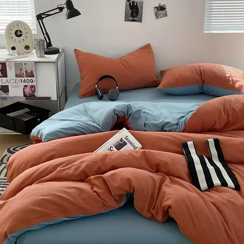 Cozy orange and blue textured duvet set with striped black and white knit accessory on dark gray bubble cotton quilt set