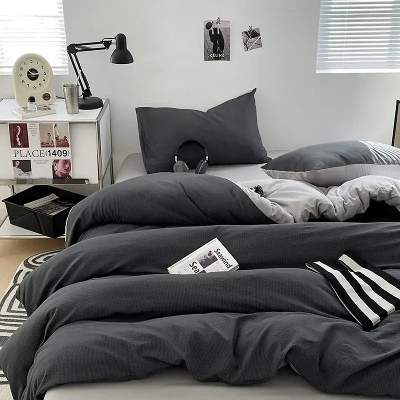 Dark gray textured duvet set with matching pillows and a striped knit blanket in bubble cotton quilt sets
