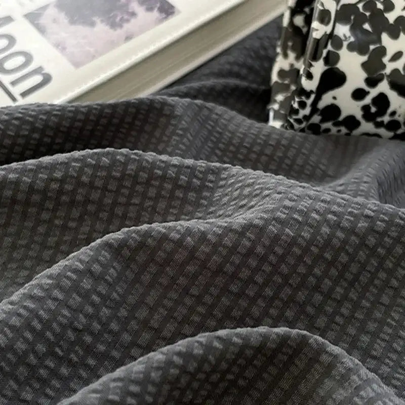 Textured dark gray waffle knit fabric showcasing a key detail of bubble cotton quilt sets for bedroom use