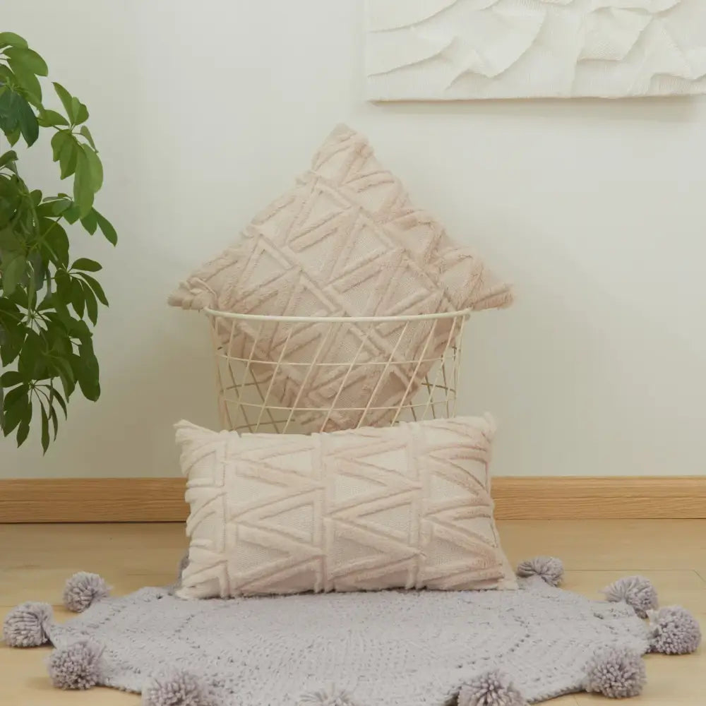 Beige textured throw pillows with geometric diamond embroidery living cushion cover displayed with matching pom-pom rug