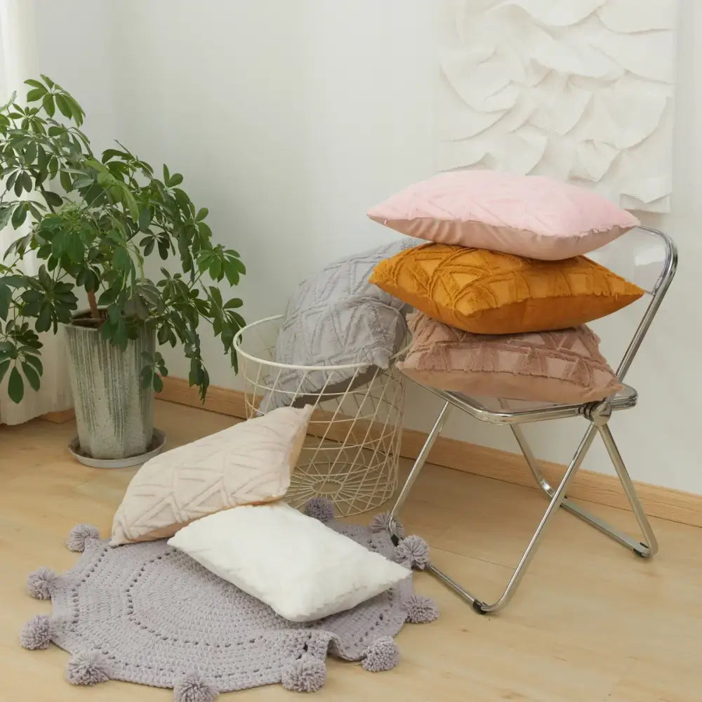 Stack of pastel pink mustard yellow and beige cushion covers with textured earthy geometric diamond embroidery living room design