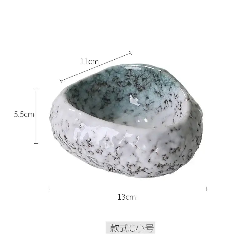 A handcrafted decorbites ceramic dessert plate with textured speckled white gray exterior and soft blue green interior