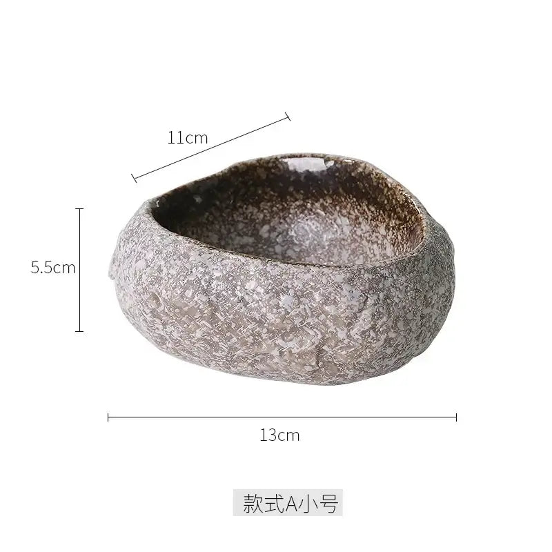 A rustic handcrafted decorbites ceramic dessert plate with speckled gray brown glaze and an irregular organic shape