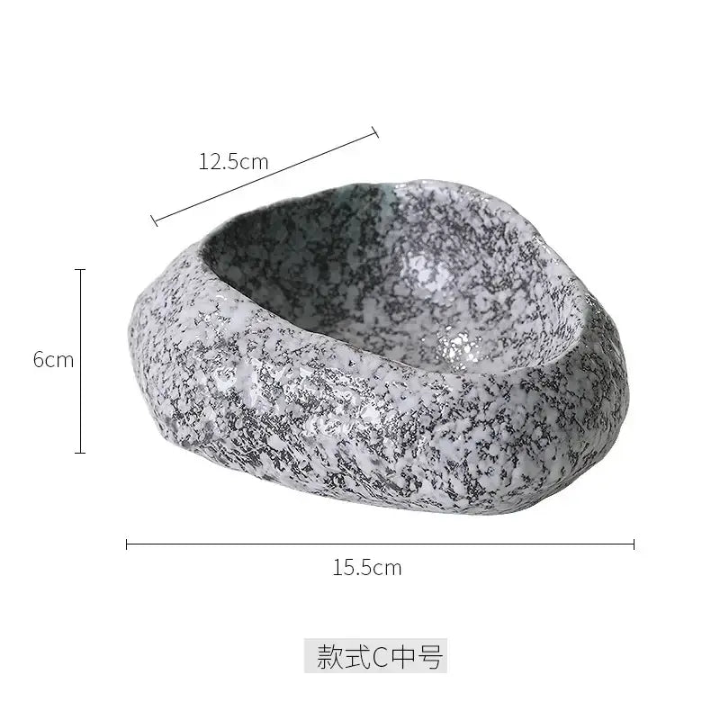 A gray and white speckled decorbites ceramic dessert bowl with a rough natural stone texture for dessert sashimi ice