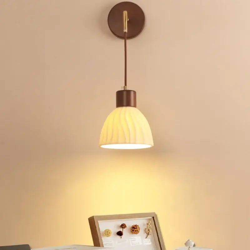 Warm-toned decorbites adjustable led wall light with textured cream glass shade and dark bronze metal bedroom sconce