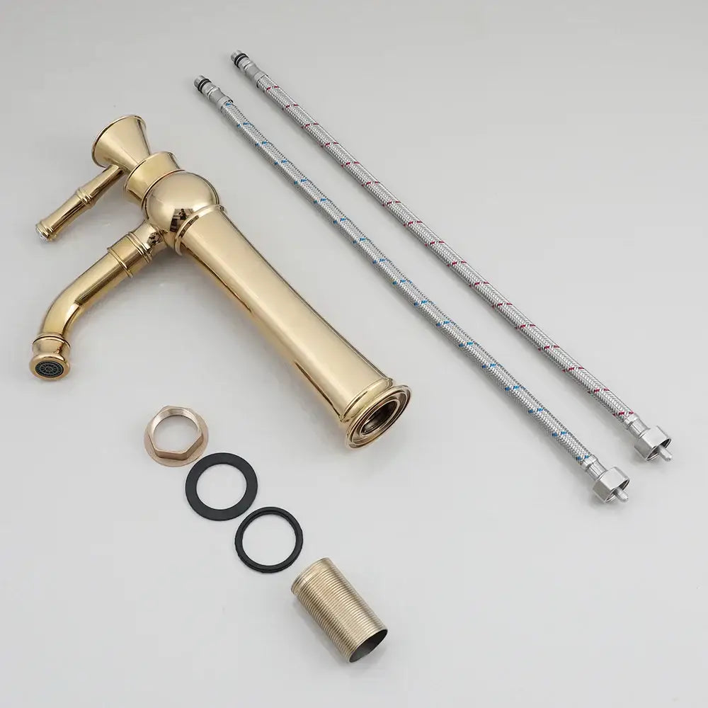 Brass-finished vintage-style bathroom faucet with tall spout and decorative handles in decorbites golden ceramic basin set