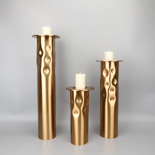 Set of three decorbites golden metal candlestick holders with textured wavy surface for dining room decor