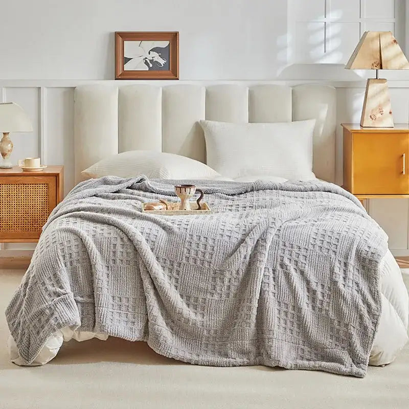 A soft light gray textured gray coral fleece blanket with diamond-patterned knit weave for bedroom use