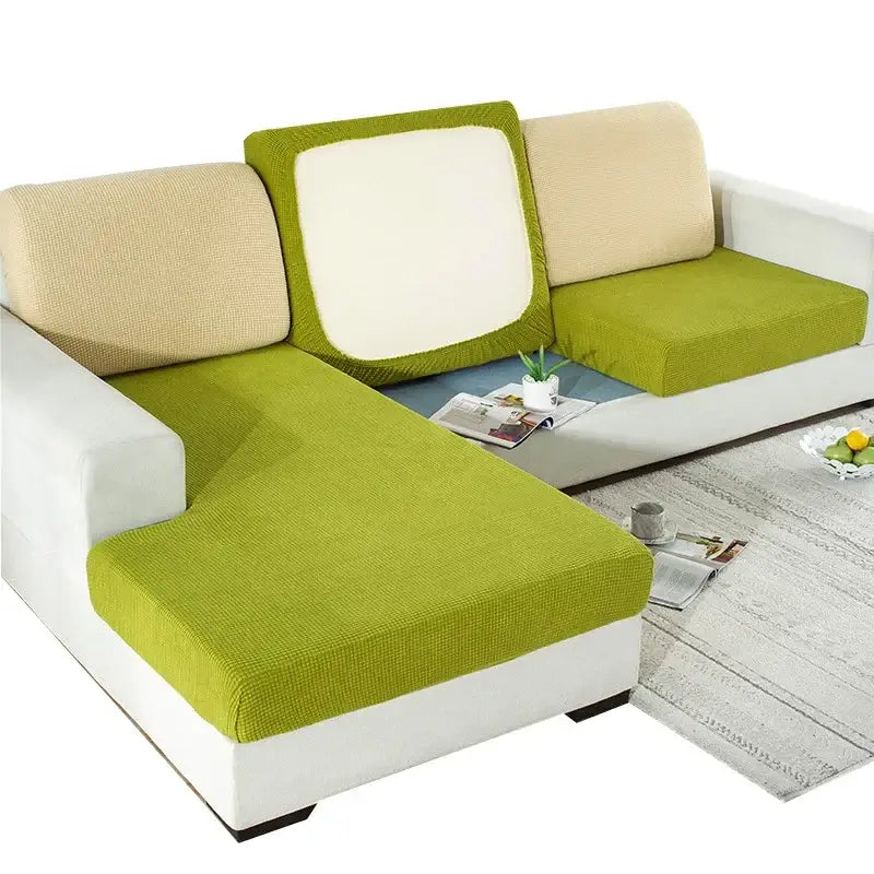 Textured green and beige elastic sofa cover with a stretchy fabric weave for living room furniture protection