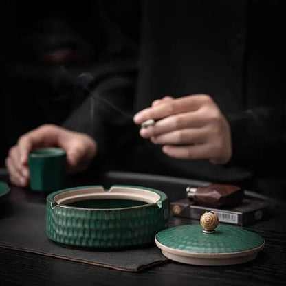 Textured green ceramic ashtray with lid featuring hammered finish and golden knob for living room smoking accessory