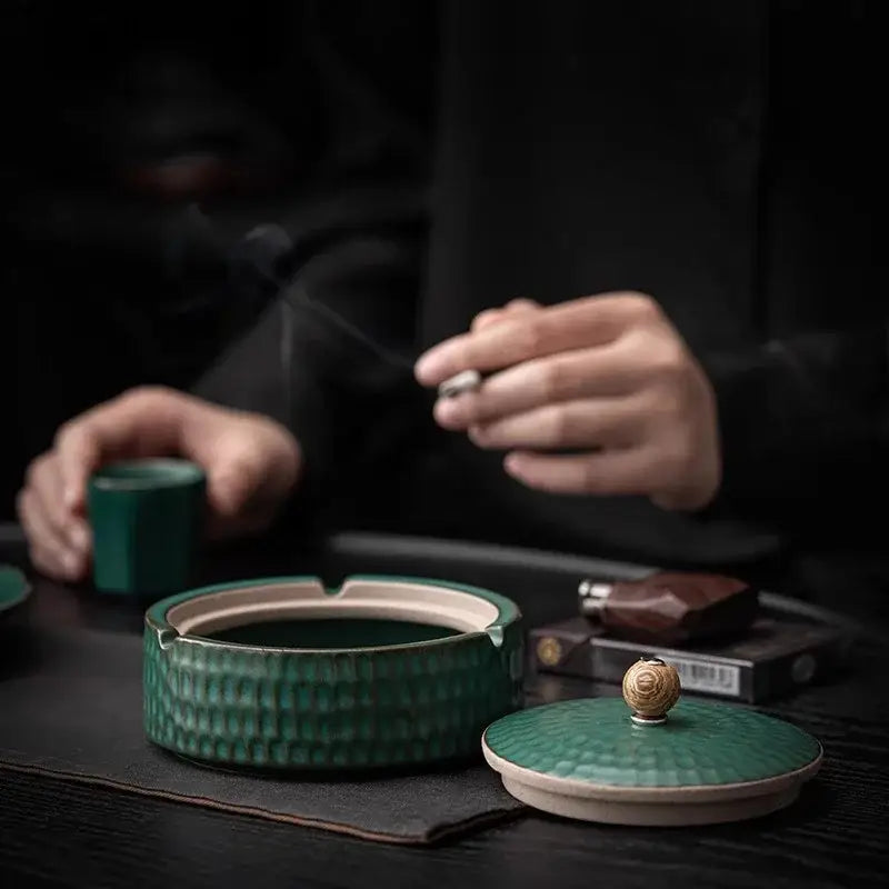 Textured green ceramic ashtray with lid featuring hammered finish and golden knob for living room smoking accessory