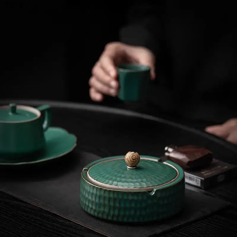 Teal green ceramic ashtray with hammered texture and gold-toned knob lid for living room smoking accessory