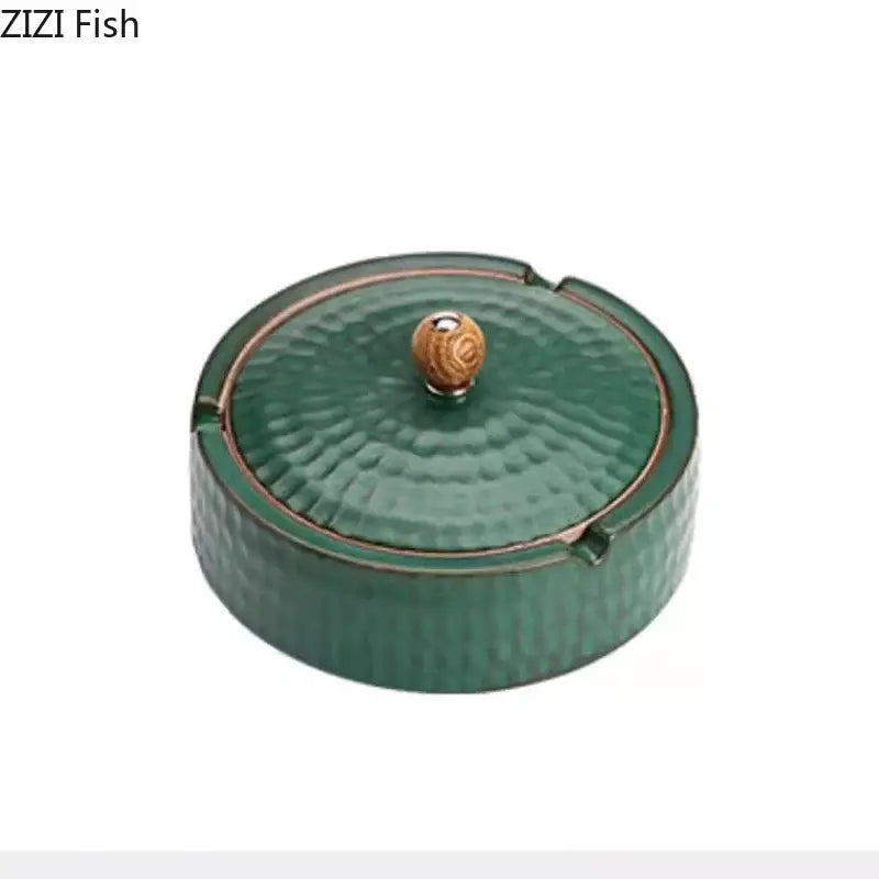 Textured green ceramic ashtray with lid featuring a hammered finish and wooden knob for living room smoking use