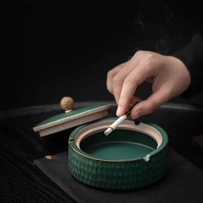 Green ceramic ashtray with textured ribbed exterior and matching lid with wooden knob for living room use