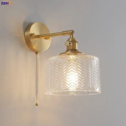 Gold-toned brass wall sconce with embossed chevron clear glass shade and pull-chain switch for bedroom lighting