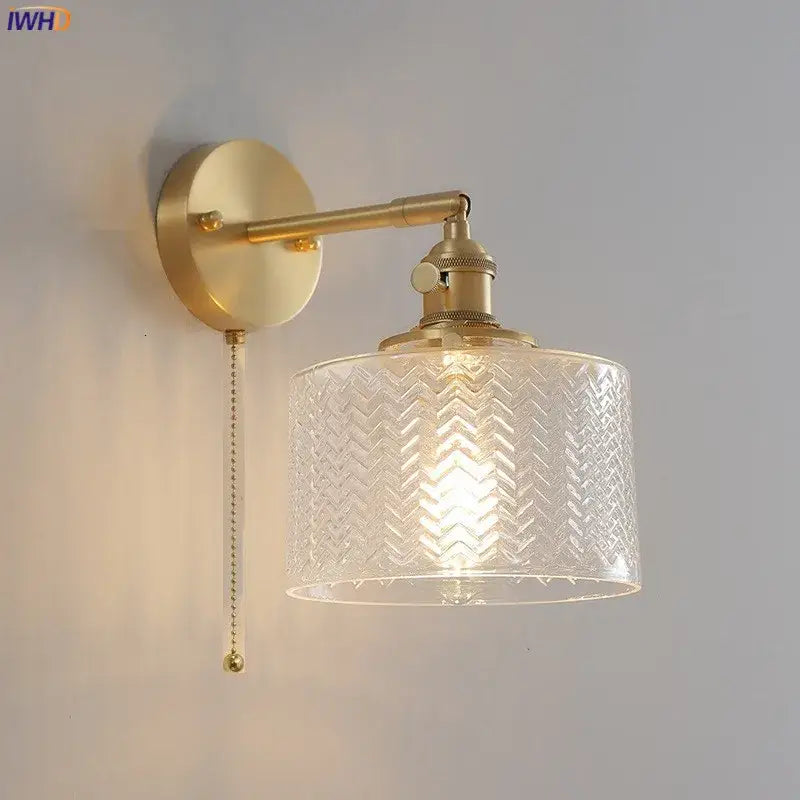 Gold-toned brass wall sconce with embossed chevron clear glass shade and pull-chain switch for bedroom lighting