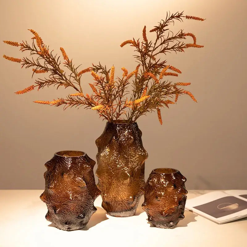 Set of three amber-colored textured sea cucumber glass vases with organic shapes for living room decor