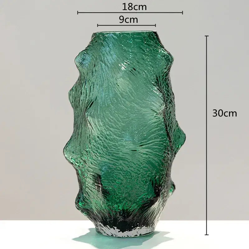 A tall textured green sea cucumber glass vase with wavy organic shape and black base for living room decor