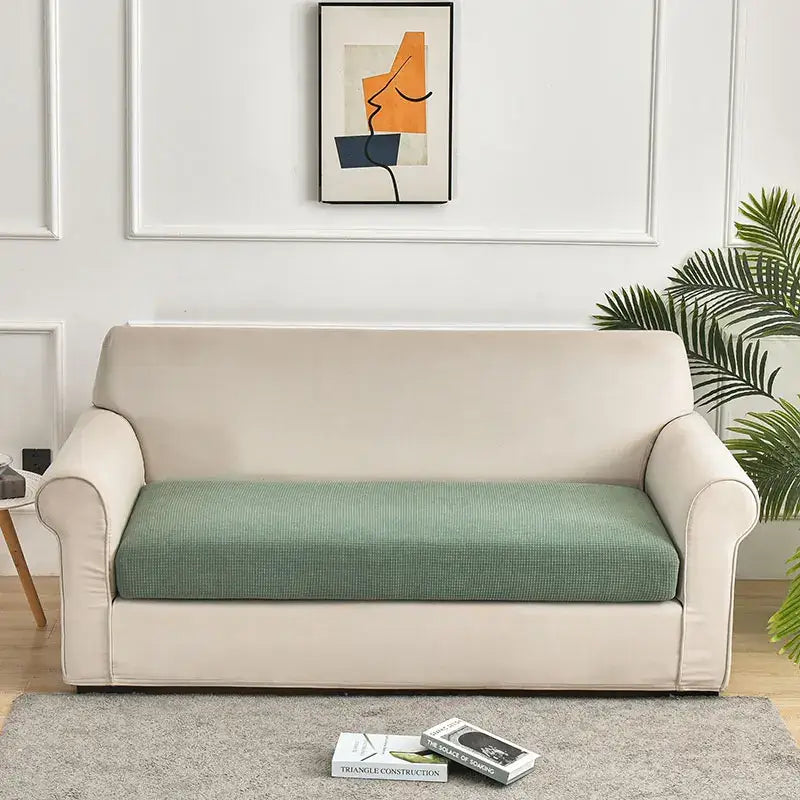 Beige sofa with a textured green waterproof elastic sofa cover perfect for living room slipcover use