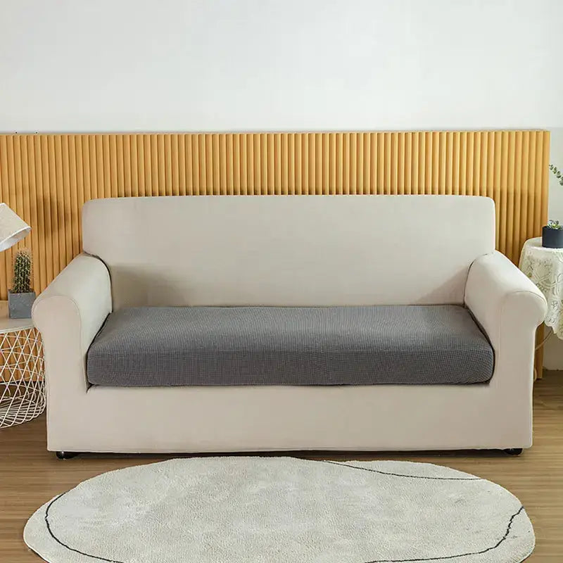 Cream-colored stretch sofa cover with textured gray seat cushion designed as a textured green waterproof elastic sofa cover slipcover