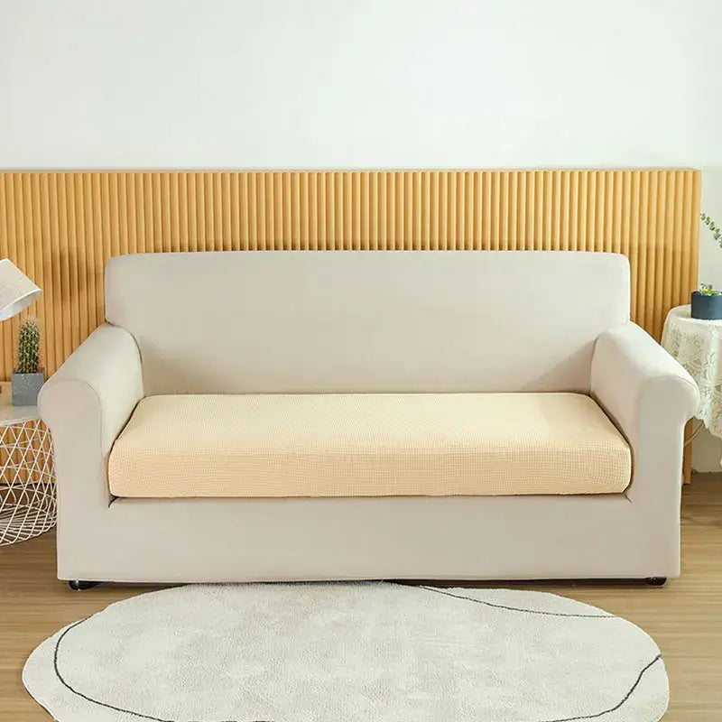 Cream-colored stretchy sofa cover with subtle textured pattern for living room slipcover use