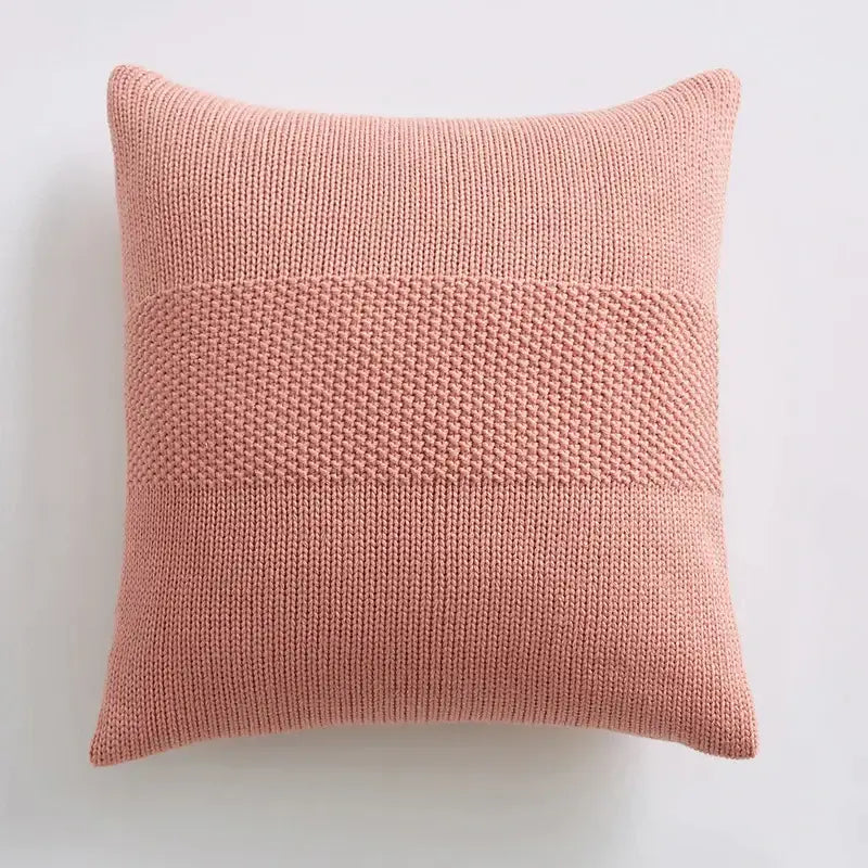 A soft blush pink knit cushion cover with textured ribbed pattern and central denser knit band for living room decorbites
