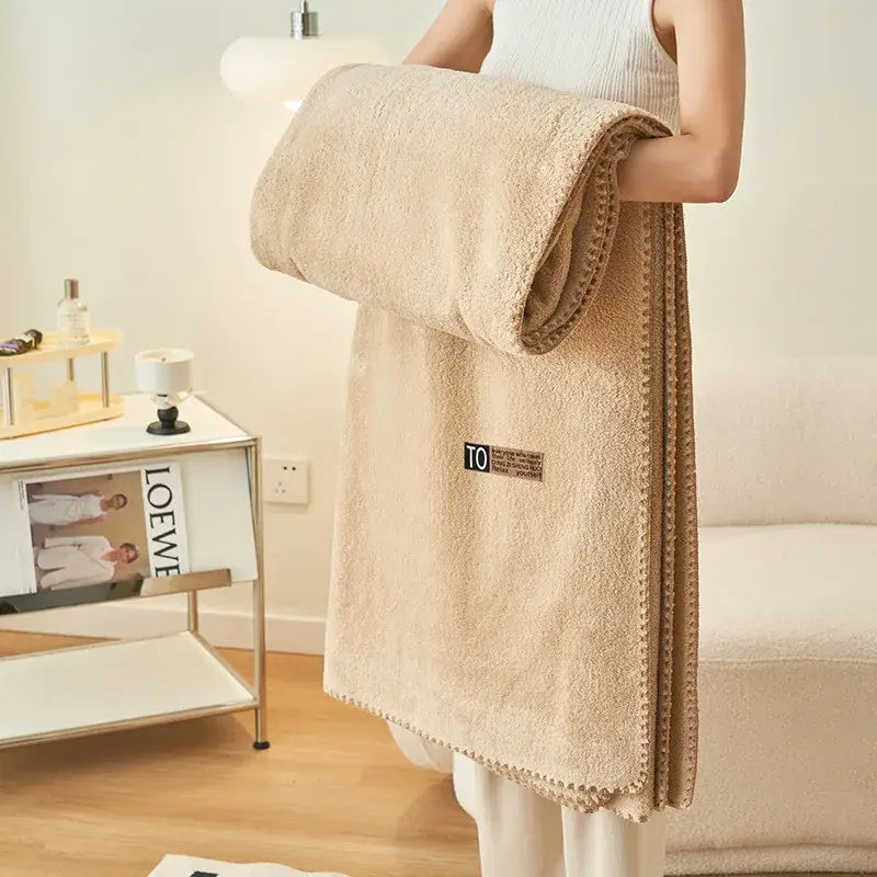 Beige plush towel with textured looped terry cloth and decorative stitched border for decorbites cloud comforter use