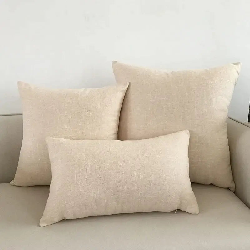 Beige linen throw pillows in varying sizes arranged on a light decorbites ivory sofa with ivory sofa cushion covers