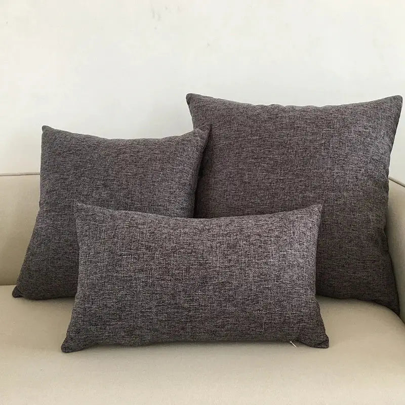 Three dark gray textured throw pillows with woven pattern on a decorbites ivory sofa cushion for elegant cushion cover decor