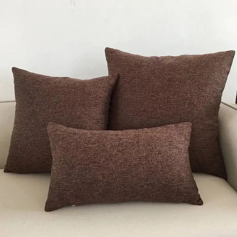 Three brown textured cushion covers arranged on a decorbites ivory sofa for living room woven throw pillow decor