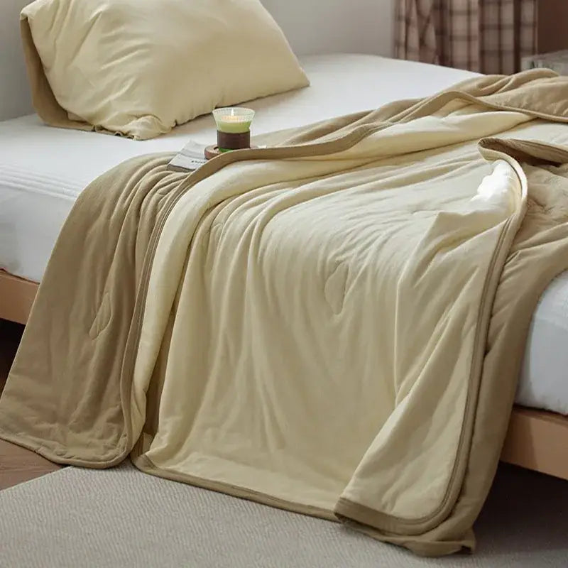 Cream-colored decorbites cotton summer comforter with soft textured surface and matching border for cooling bedroom use