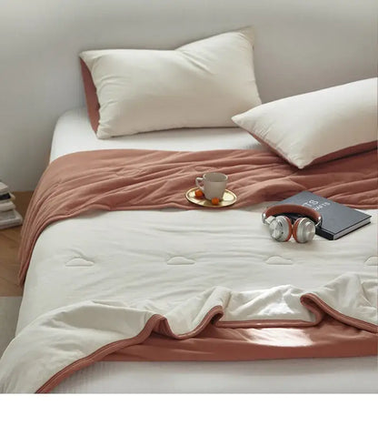 Soft peach-colored decorbites cotton summer comforter with quilted texture and stitched edges for cooling bedroom use