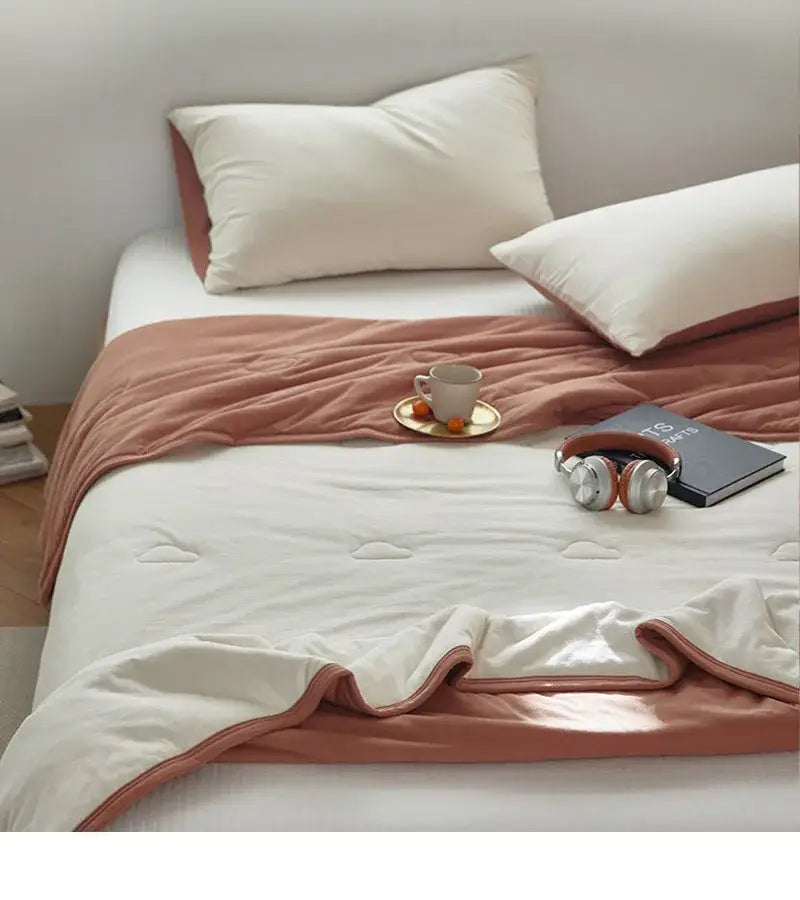 Soft peach-colored decorbites cotton summer comforter with quilted texture and stitched edges for cooling bedroom use