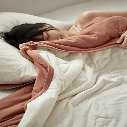 A textured pastel decorbites cotton summer comforter in white with dusty rose edges for bedroom cooling use