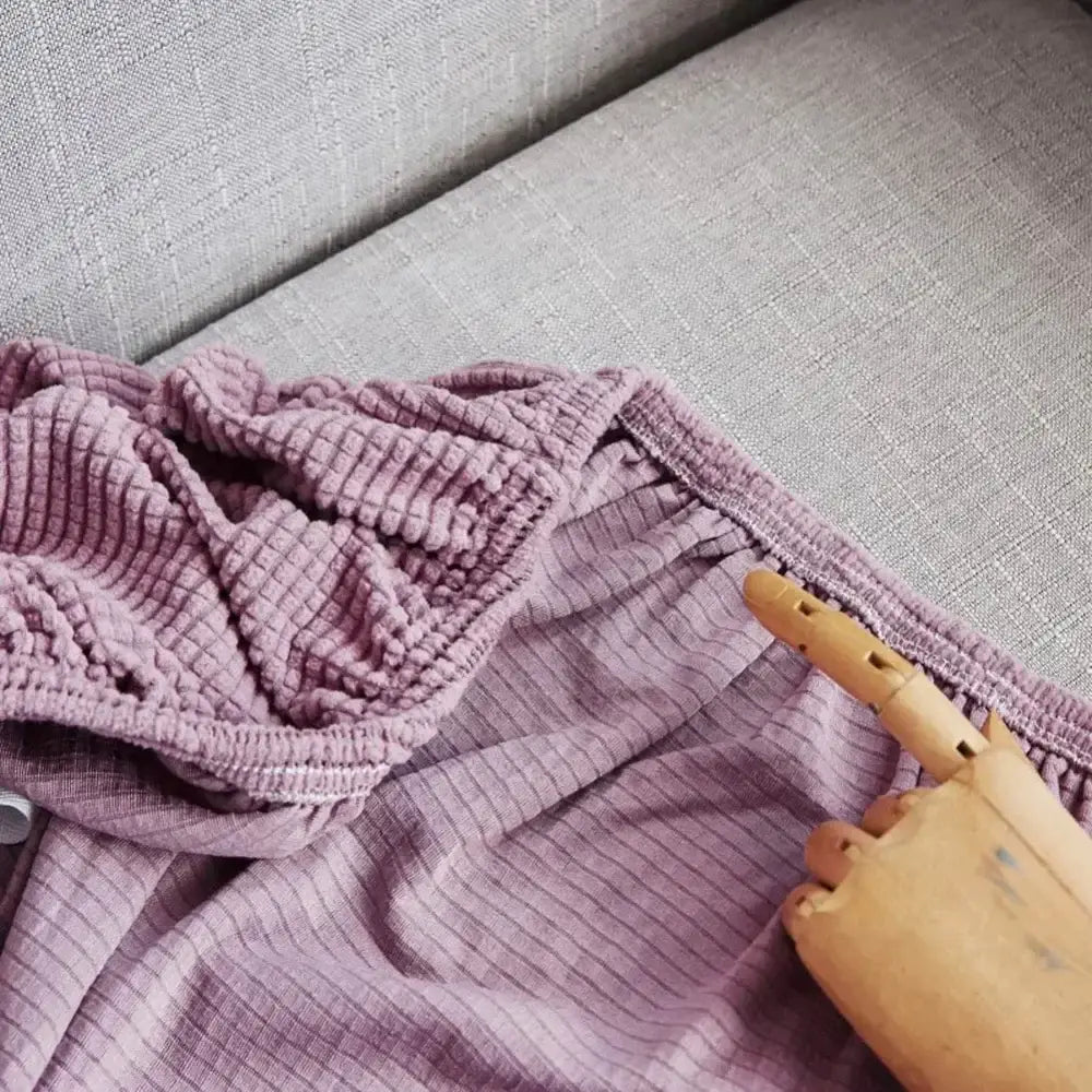 A soft lavender ribbed fabric garment with stretchy waistband on gray surface for decorbites cozy fleece sofa slipcover