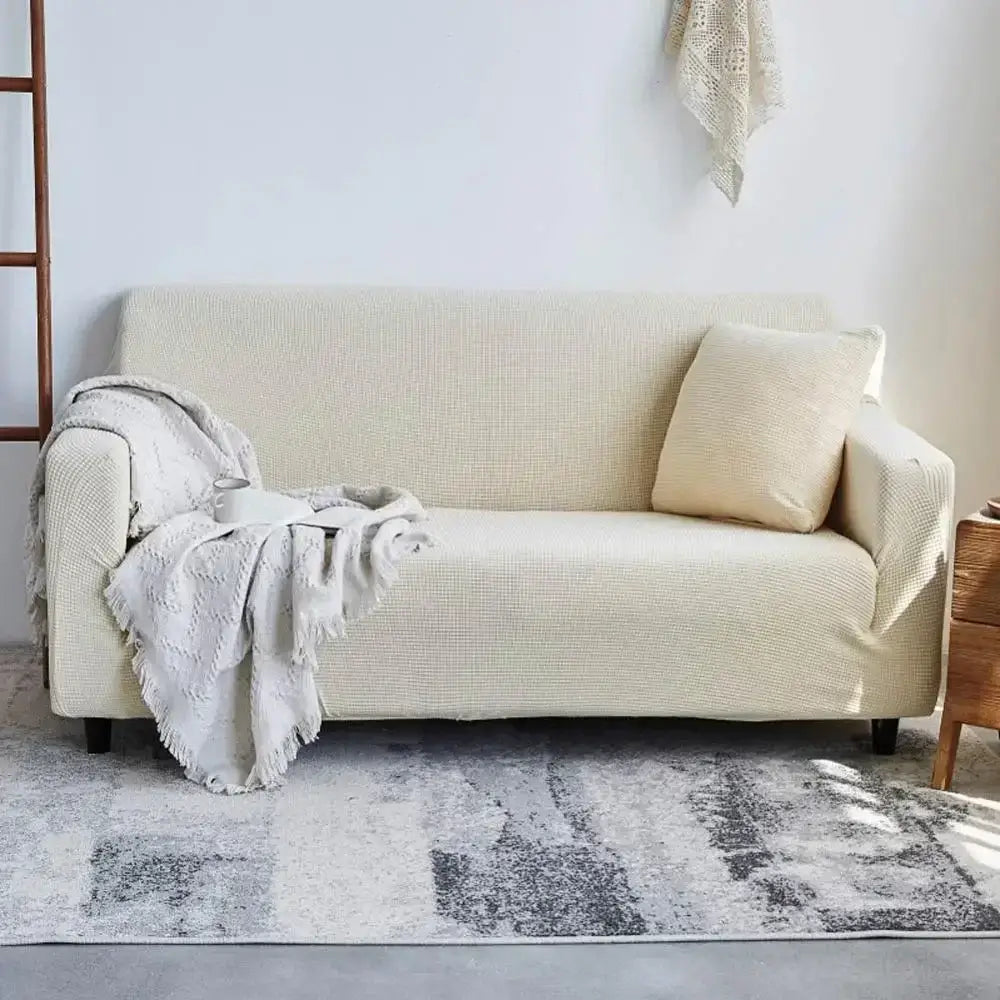 Beige textured fabric sofa slipcover with matching pillow and draped throw blanket for decorbites cozy fleece sofa wrap